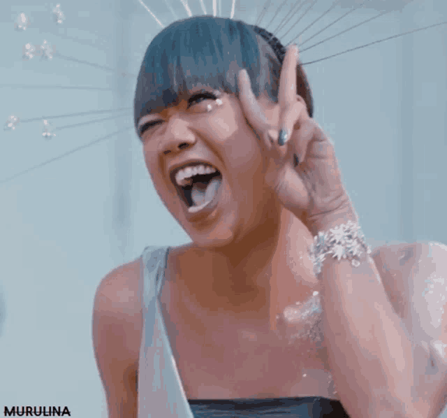 a woman making a peace sign with her tongue hanging out and the word murulina below her