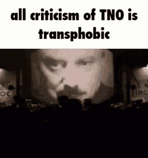 a man with a mustache is being projected on a large screen in a dark room .