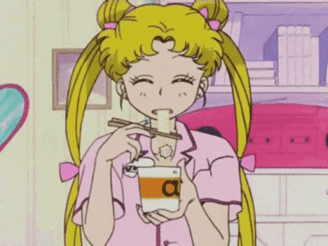 a girl is eating noodles with chopsticks from a cup that says a on it