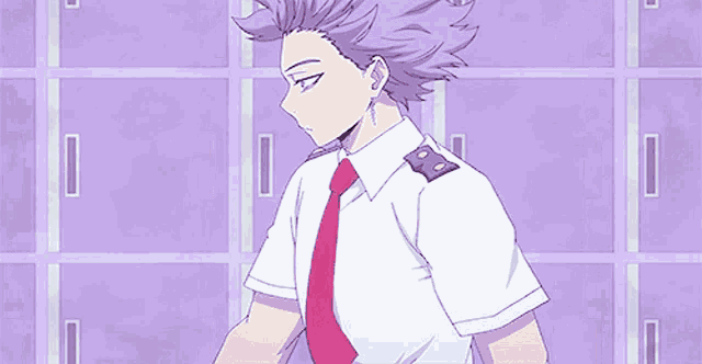 a man with purple hair and a white shirt and red tie is standing in front of lockers .