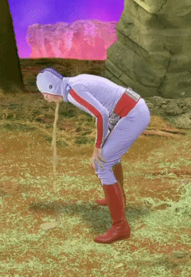 a man in a superhero costume is vomiting in the dirt