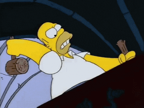 homer simpson is laying in bed holding a wooden hammer