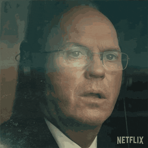 a close up of a man wearing glasses and headphones with a netflix logo behind him