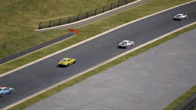 three cars are racing on a race track with the number 100 on the side of the road