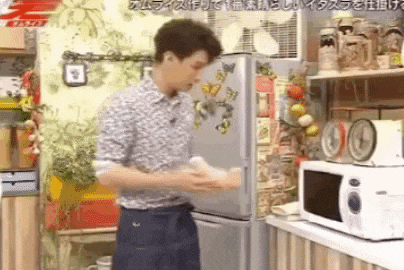 a man is standing in front of a refrigerator and a microwave in a kitchen .