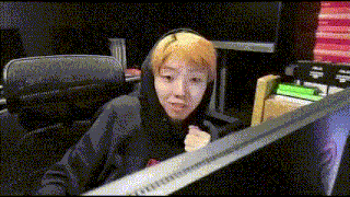 a young boy with blonde hair is sitting in front of a computer screen .