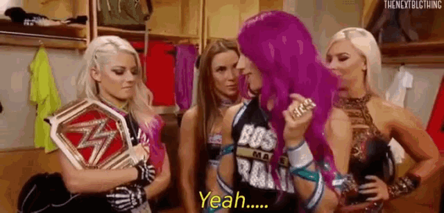 a group of women are standing next to each other in a locker room and one of them is holding a championship belt .