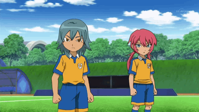 two anime characters standing next to each other with one wearing a yellow shirt with a letter g on it