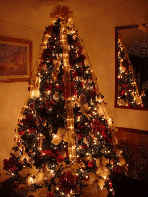 a christmas tree decorated with red and gold ornaments and lights