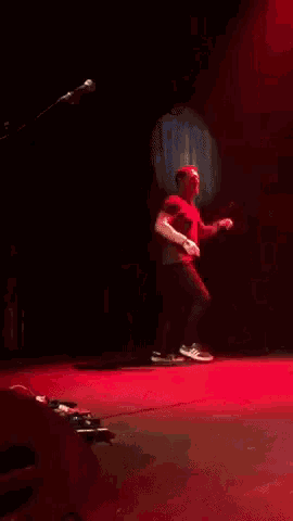 a man on stage with his arms in the air
