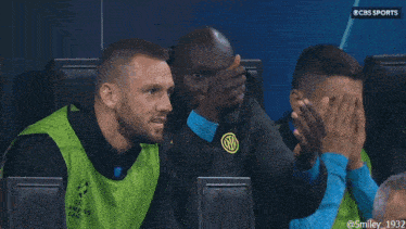 a group of men are sitting in front of a logo for cbs sports