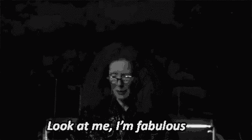 a black and white photo of a woman with glasses and big hair saying `` look at me , i 'm fabulous ''