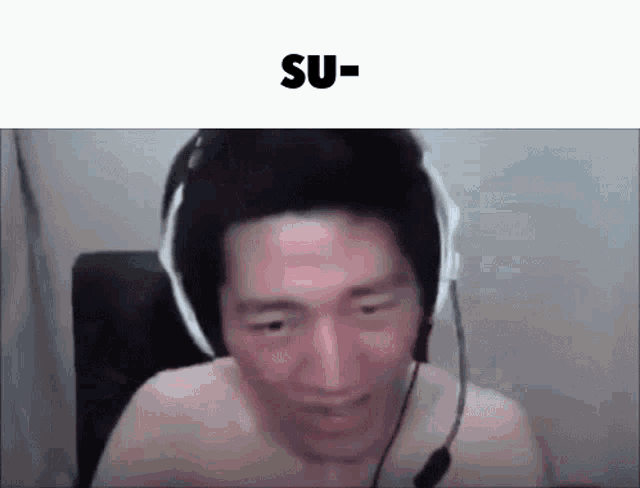 a shirtless man wearing headphones and a microphone is sitting in front of a computer screen .