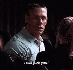 a man in a blue shirt is talking to a woman and saying `` i will fuck you ! ''