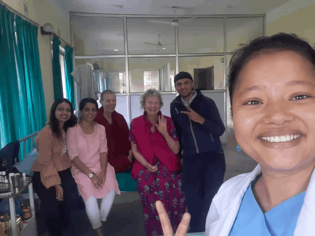 a group of people are posing for a picture and one of them is giving a peace sign