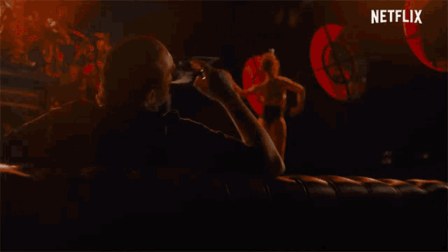 a man in a dark room with a netflix logo on the bottom right