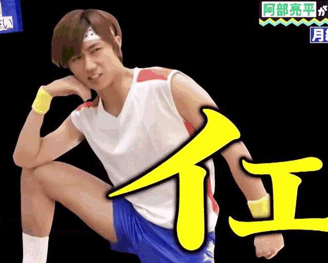 a man wearing a headband and shorts is kneeling down with chinese writing behind him