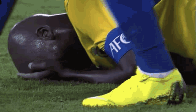 a soccer player is laying on the ground with a afc ankle brace on his leg