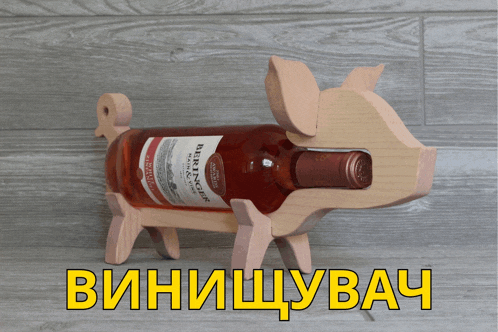 a wooden pig holds a bottle of wine