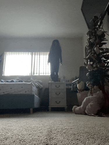 a person standing in a bedroom next to a dresser
