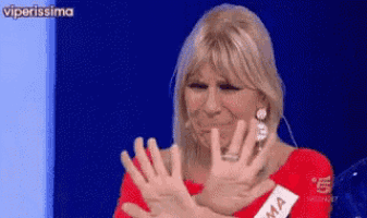 a woman in a red shirt is making a stop sign with her hands
