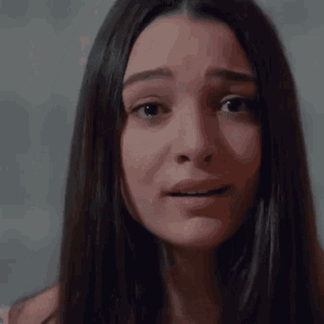 a close up of a woman making a sad face