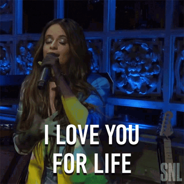a woman singing into a microphone with the words i love you for life above her
