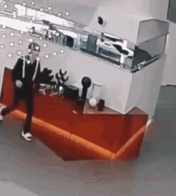 a man is walking in a room with a red counter and a white counter .