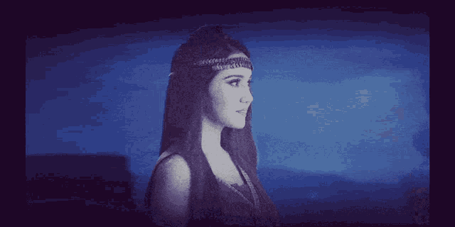 a woman with a headband on her head is standing in front of a blue sky