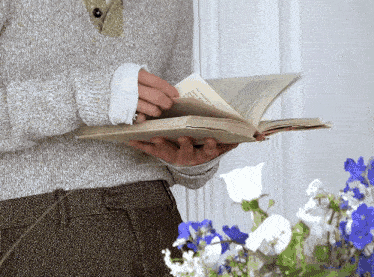 a person holding a book with a page that says ' i 'm sorry ' on it