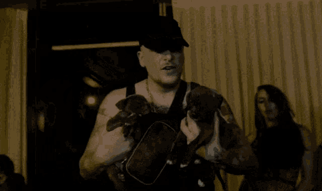 a man is holding two puppies in his hands