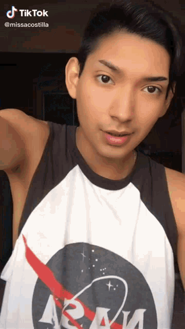 a man wearing a nasa tank top with a red arrow
