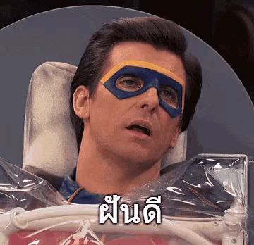 a man wearing a superhero mask is laying in a plastic bag with a foreign language written on it