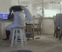 a person sitting on a stool in front of a computer with a facebook logo on it