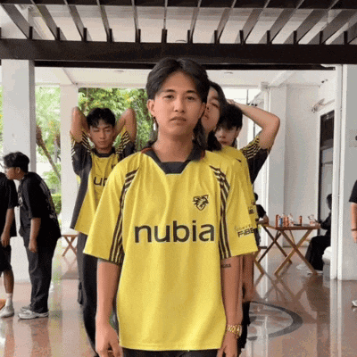 a man in a yellow nubia shirt stands in a line