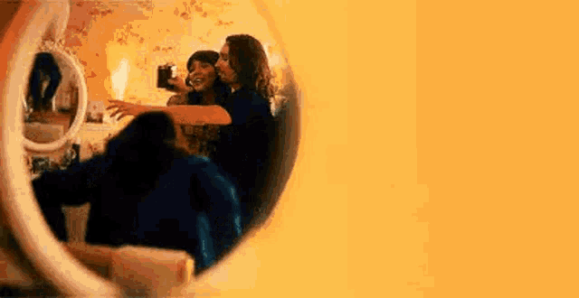 a man and a woman are dancing in front of a mirror .
