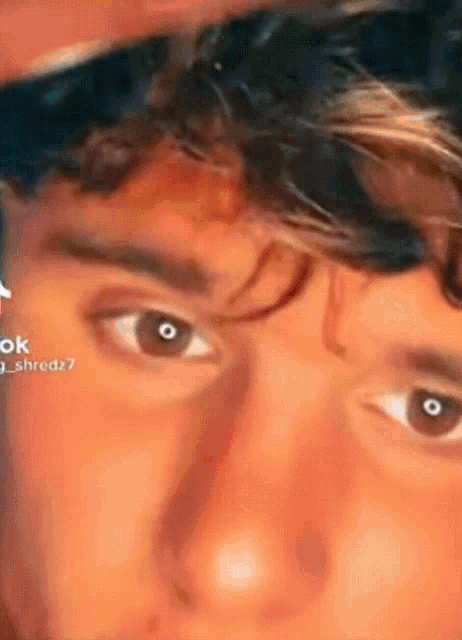 a close up of a young man 's face with a blurred background .