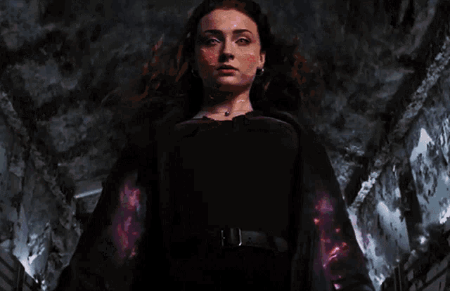 a woman in a black dress is surrounded by flames