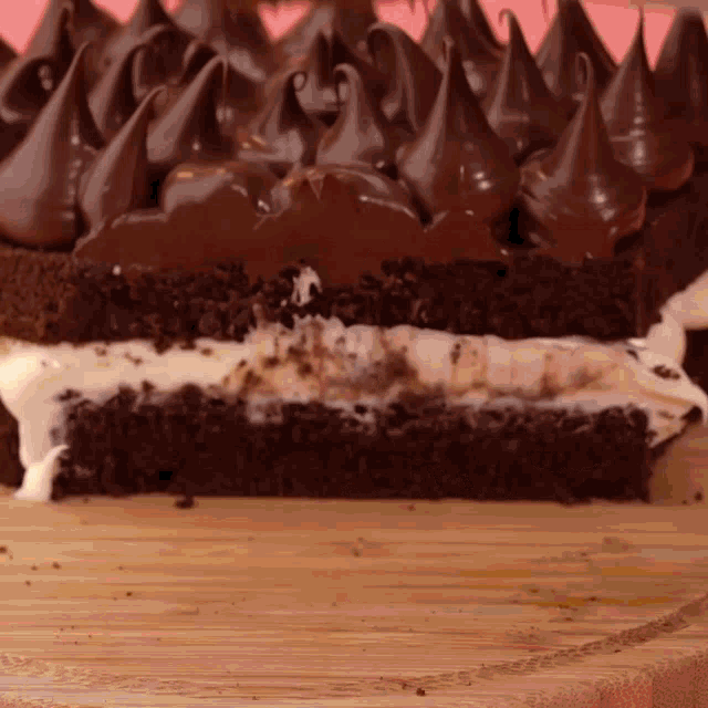 a chocolate cake with a slice taken out of it is on a wooden cutting board