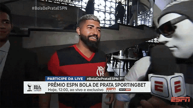 a man wearing a flamengo shirt is being interviewed by a espn reporter
