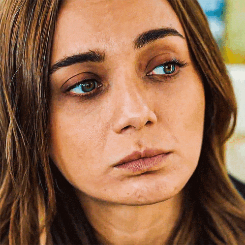a close up of a woman 's face with a tear running down her cheek