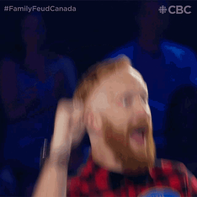 a blurry picture of a man with a beard wearing a plaid shirt