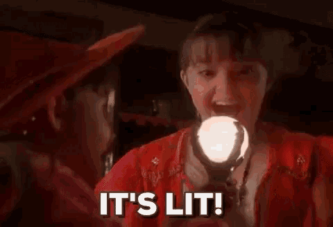 a woman in a red dress is holding a light in her mouth and saying `` it 's lit ! ''