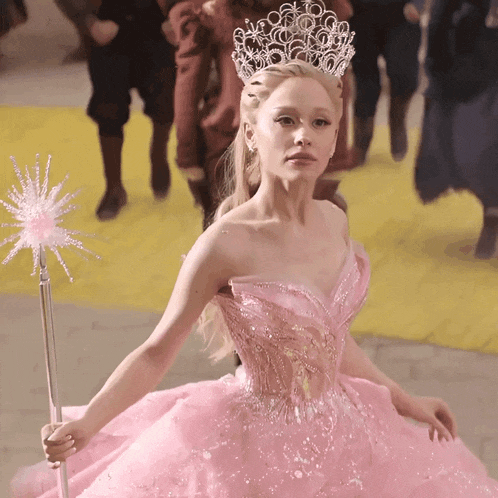 a woman in a pink dress with a crown on her head