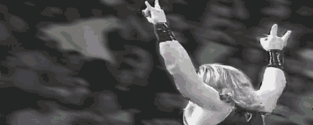 a black and white photo of a person with their arms up