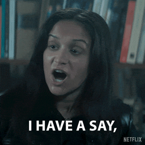 a woman says " i have a say " in front of a book shelf