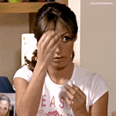 a woman wearing a t-shirt that says easy wipes her face