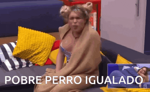 a woman wrapped in a blanket is sitting on a couch and the caption says pobre perro igualado