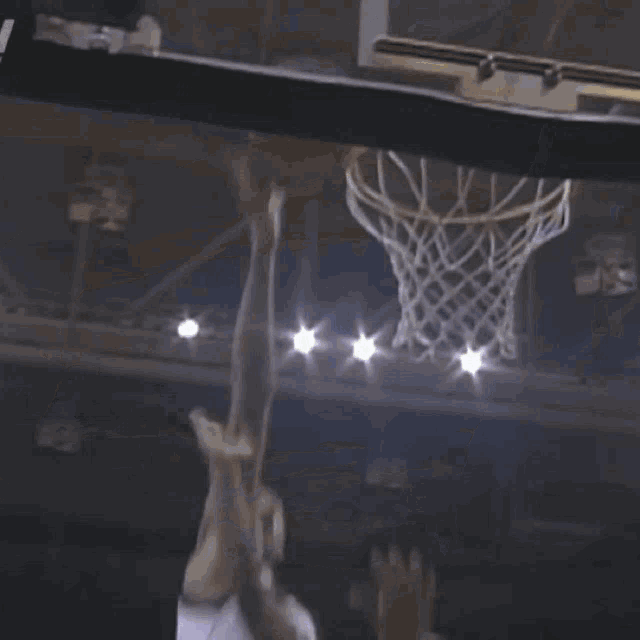 a basketball player with the number 2 on his jersey is jumping for the ball