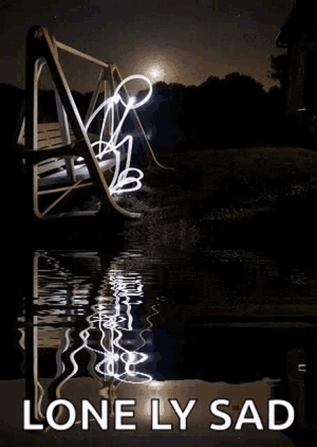 a light painting of a person sitting on a swing in the water at night .